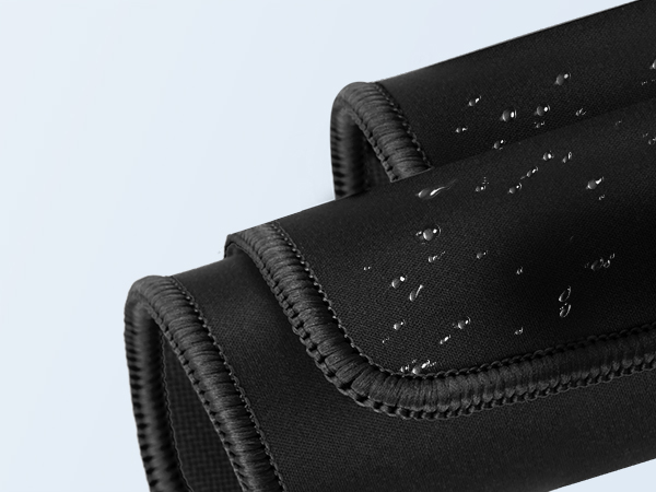 Close-up of black neoprene material with water droplets on surface, showing water-resistant properties and stitched edges.