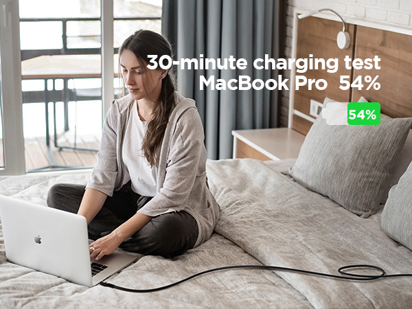 Laptop '100W PD3.0' charging indicator with progress bar, shown on wooden floor with exercise