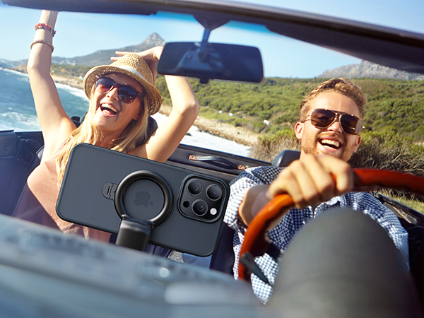 Black smartphone case with circular camera lens protector and multiple cutouts for phone cameras. Shown in use during a convertible car ride.