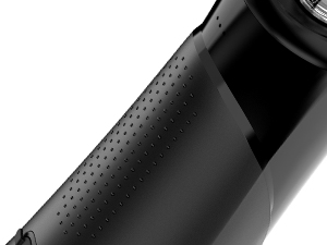 Close-up of a black textured surface, possibly part of a product or material. Perforated pattern visible.