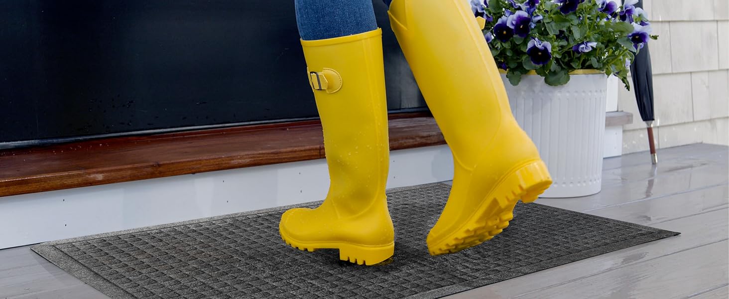 yellow rain boots wiping across doormat at outdoor entry door