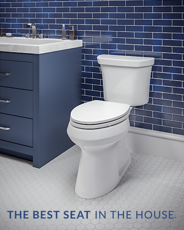 Blue bathroom with tiles and a blue vanity next to a white toilet with modern slow close lid