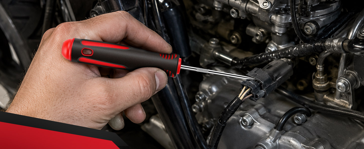 Pick tool positioned beside an electrical connector on a motorcycle engine.