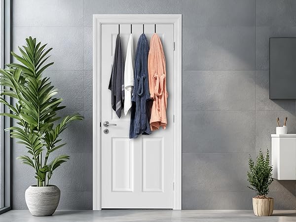 Two bath towels and two bathrobes hang from four hooks on bathroom door