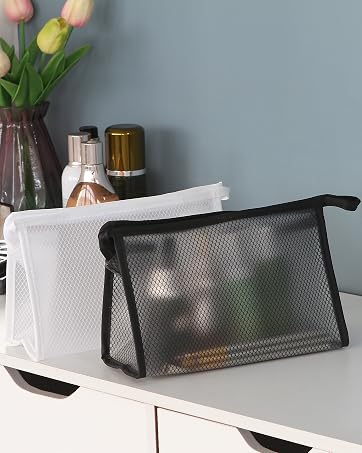2 black and white cosmetic bags on a white desk