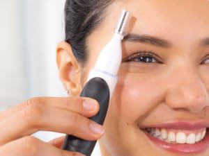 Woman using eyebrow trimmer