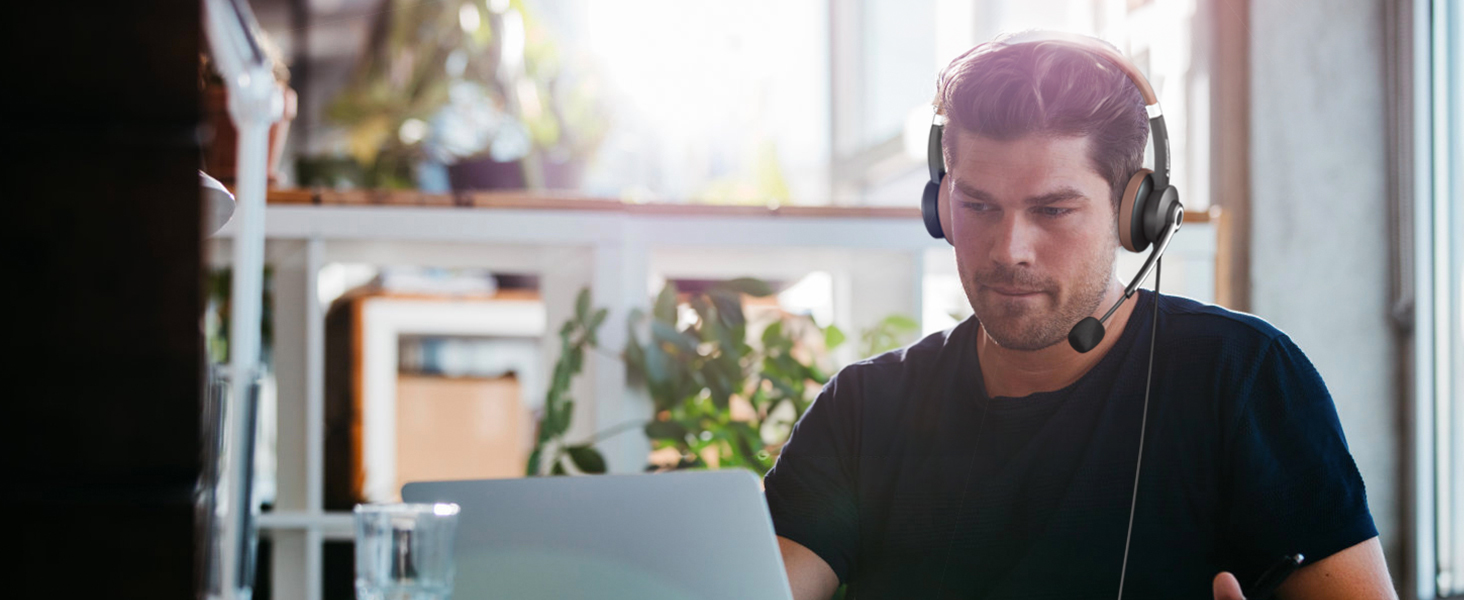 A man wears ARA700 wired headset at work in an office.