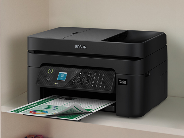 Black WorkForce WF-2930 printer sitting on bookshelf with prints in output tray.