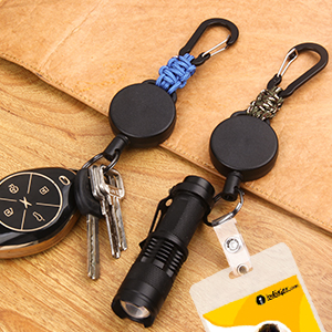 Two retractable key holders with carabiner clips. One black, one blue. Attached are keys, a small flashlight, and an ID card.