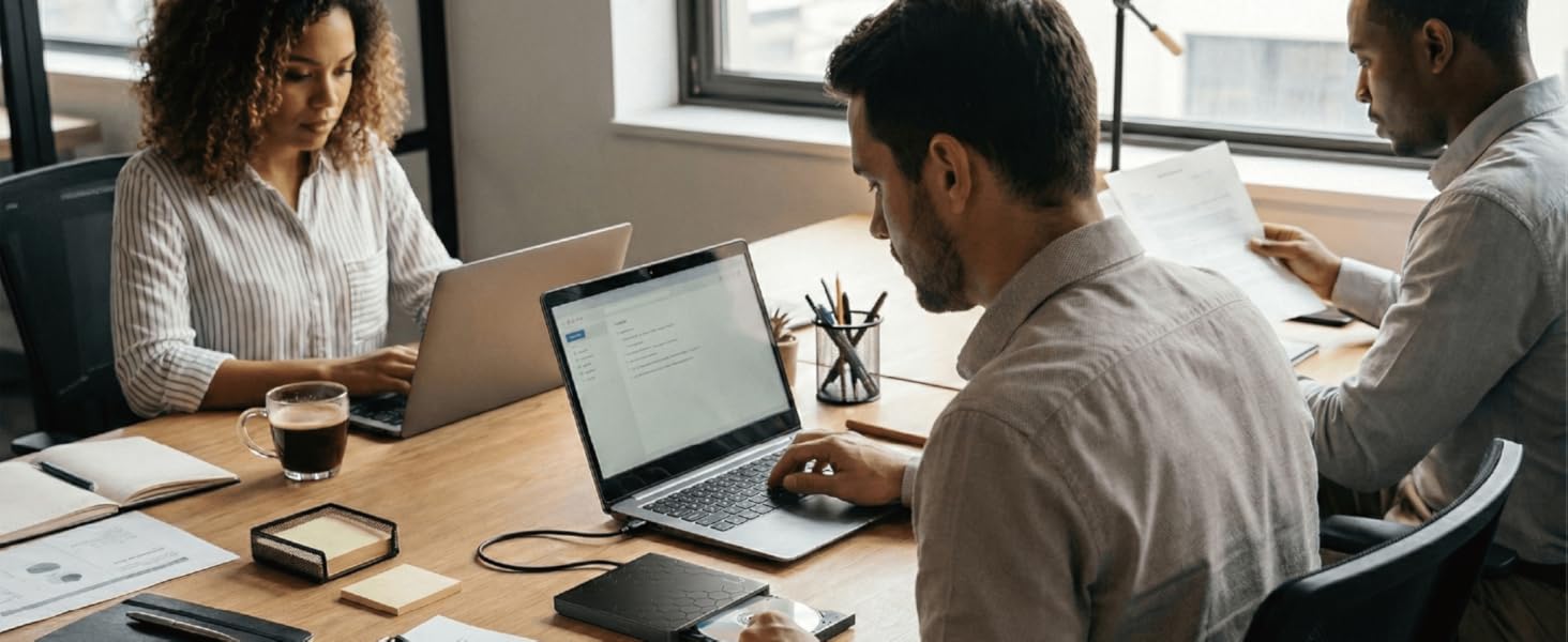 Office?scene?of?employees?working?on?laptops?using?ERGOOCUSHION?External?DVD?Drive,?rear?view.