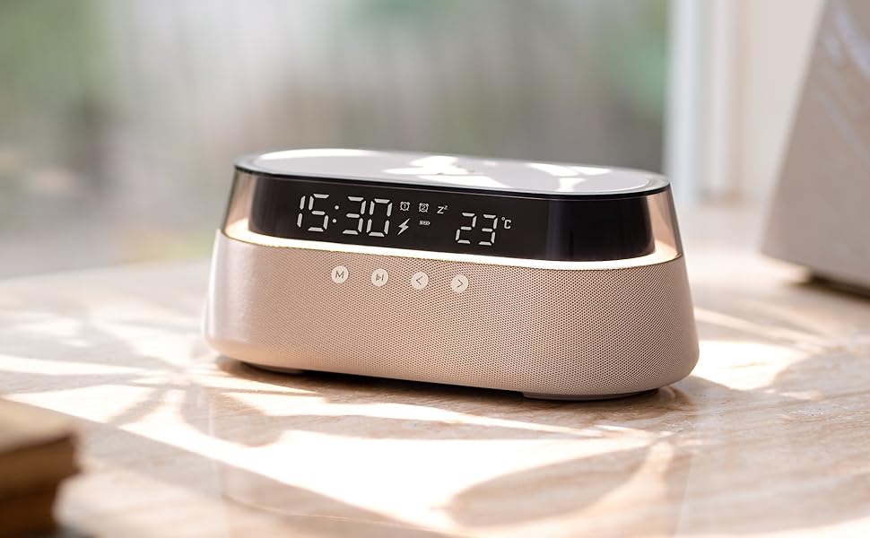 Modern digital alarm clock with LED display showing time and temperature. Rose gold or champagne-colored base with textured pattern and black top panel.