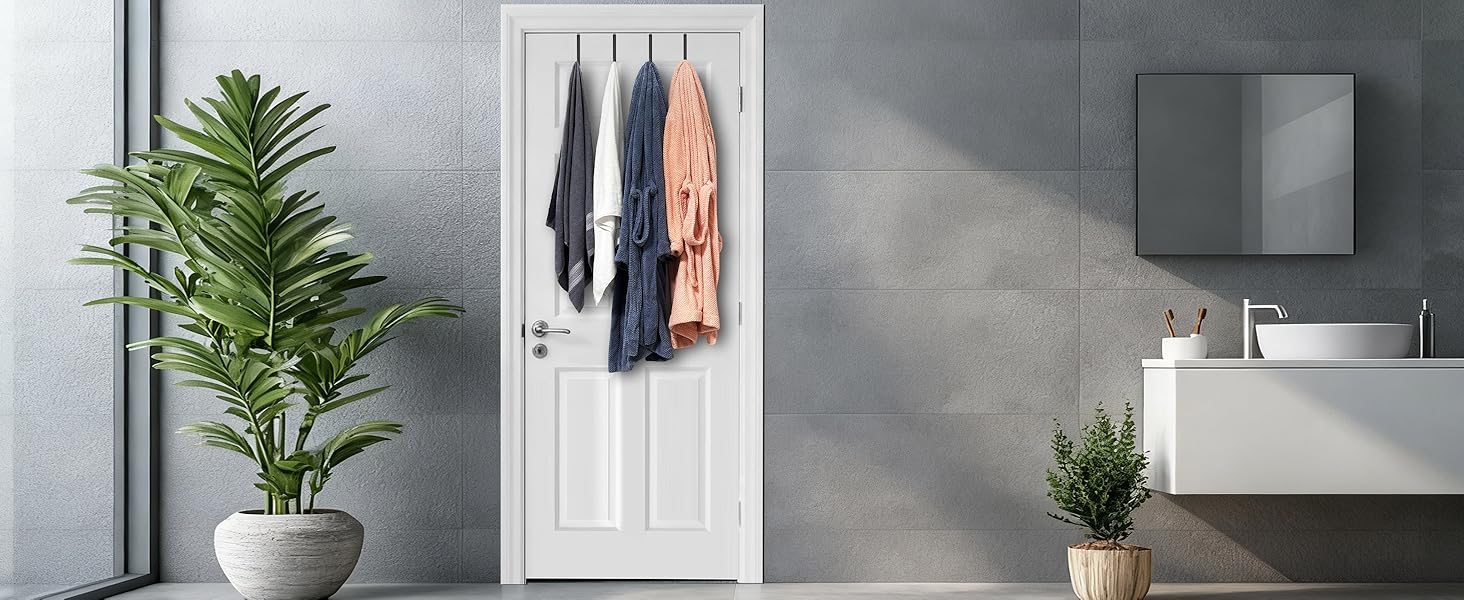 Two bath towels and two bathrobes hang from four hooks on bathroom door