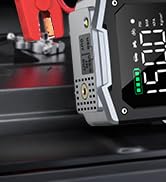 Close-up of a digital watch face with a red and black display. The time shows 5:53. The watch has a rugged, angular case design with visible screws or rivets.