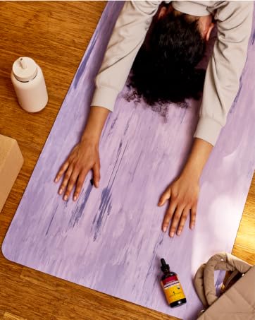 Woman in child&amp;amp;#39;s pose with a bottle of Herb Pharm&amp;amp;#39;s Ashwagandha on the mat.