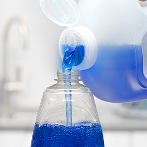 A person refilling a bottle of Dawn Platinum using a Dawn Platinum refill jug.