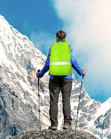 a man with a backpack and ski poles standing on a mountain.