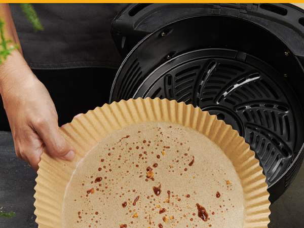 Air fryer liners for ninja style baskets offering a precise round fit during cooking.