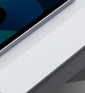 Close-up view of sleek device edge, possibly a smartphone or tablet. Shows metallic frame against white and dark surfaces.