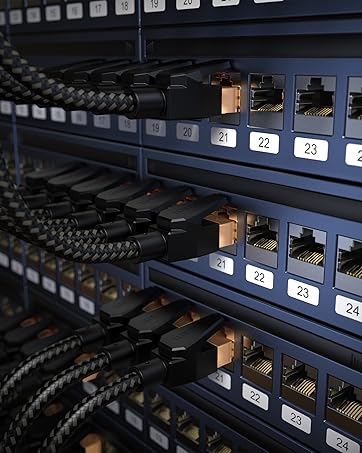 Close-up of network patch panel with numbered ports. Multiple black Ethernet cables connected, showing organized server rack wiring for data center or IT infrastructure.