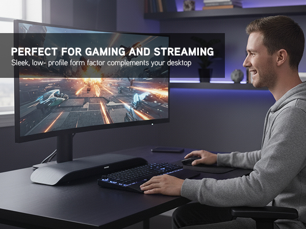 Man gaming at desk with curved monitor and Soundblade beneath screen in modern LED-lit workspace