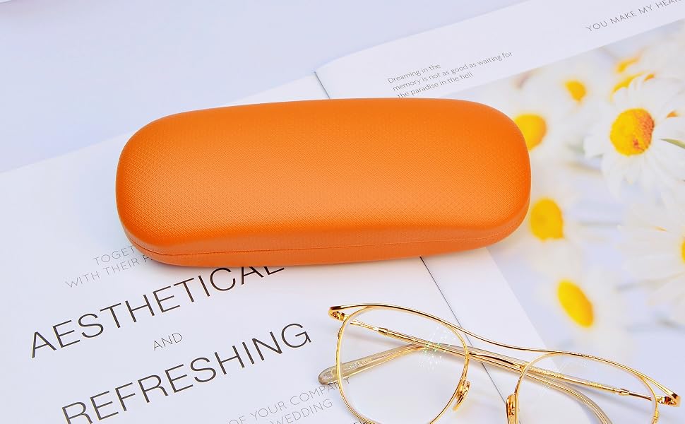 Orange textured eyeglasses case alongside gold-framed glasses. White paper with 'AESTHETICAL REFRESHING' visible. Yellow floral elements in background.