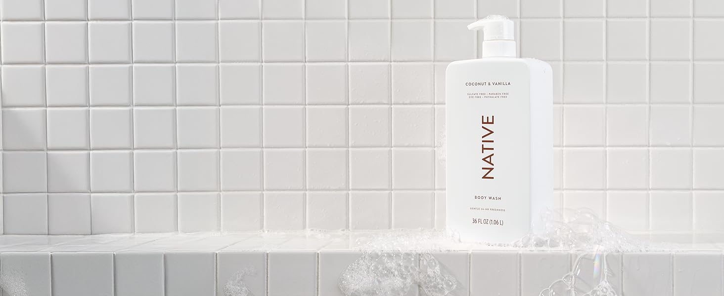 Native&amp;amp;#39;s coconut and vanilla sulfate-free bodywash shown in a shower with suds around it