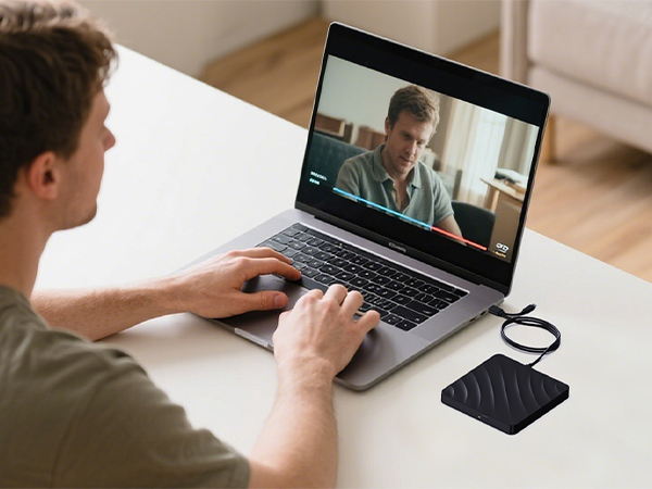 Multiple connected images showing a laptop being used for video conferencing in a home office setting, with warm lighting and wooden desk surfaces.