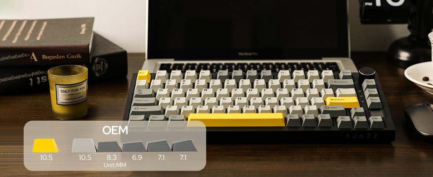 Mechanical keyboard with gray and yellow keycaps displayed on desk, alongside a small jar and book.