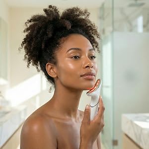 Woman using LED device with subtle golden glow along defined jawline