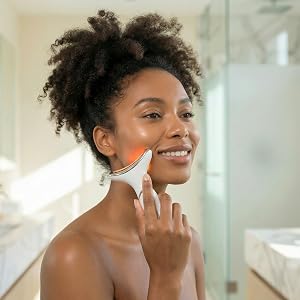 Woman holding LED skincare device with refined jawline and lifted posture