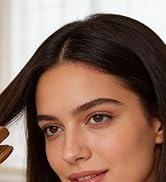 Close-up portrait against white background showing natural makeup and dark hair.