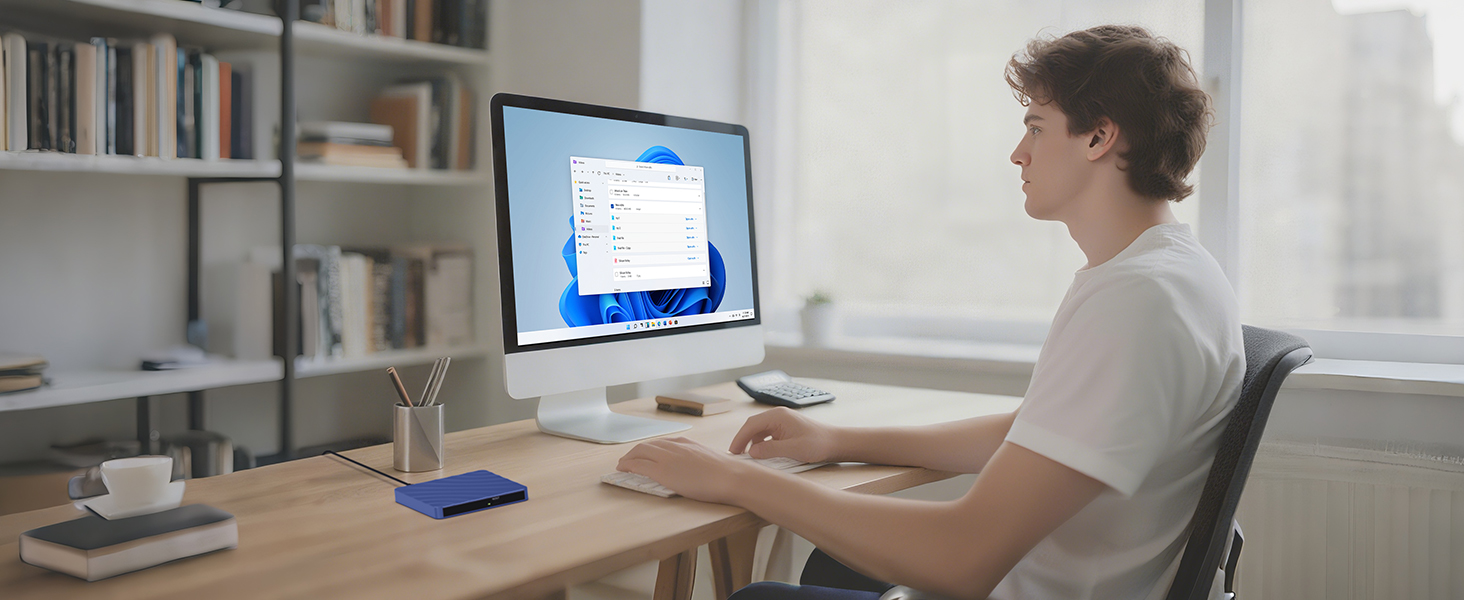 Wide shot of an office desk setup showing computer monitor and workspace in natural lighting with modern minimalist design.