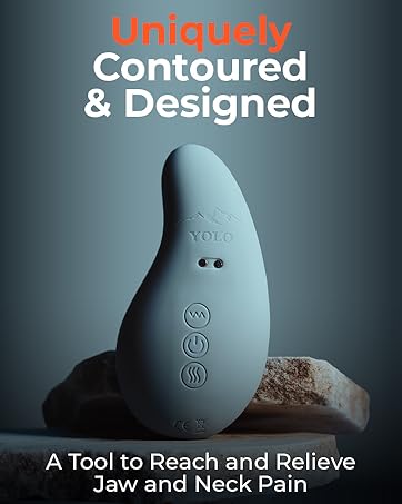 a person using the eye massager with heat on their jaw and smiling