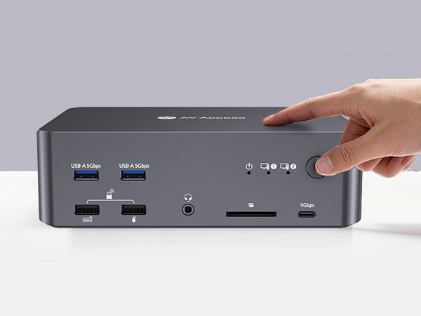 Black rectangular electronic device with multiple ports and card reader slots visible, finger pointing to top surface.