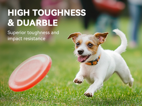 Dog toy frisbee advertised as highly durable. Small white dog chasing orange disc on grass. Text highlights superior toughness and impact resistance.