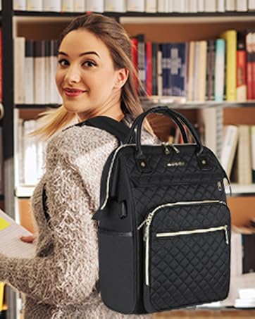 Black quilted backpack with multiple compartments and silver hardware, displayed next to bookshelves in a library setting.
