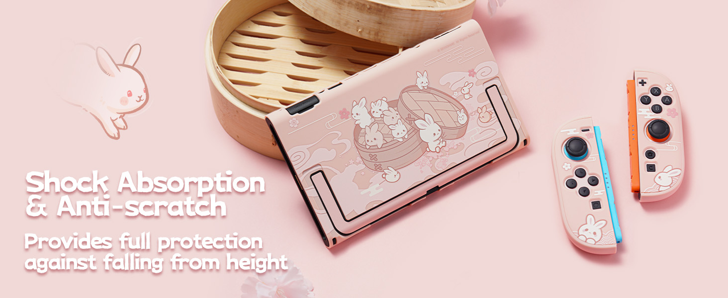 Text reads 'Shock Absorption'. Gaming accessories in pink tones including protective case and gaming controller components on pale pink background.