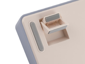 Close-up detail of a beige electronic device corner showing a slot and button configuration.
