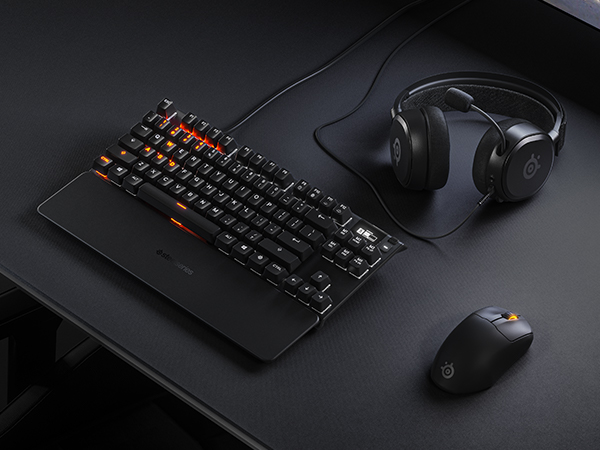 -SteelSeries desk setup with mousepad, keyboard, mouse, and headset