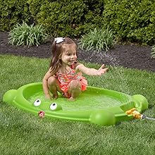 Girl standing in Splash Pad with water in it and sprinkler running