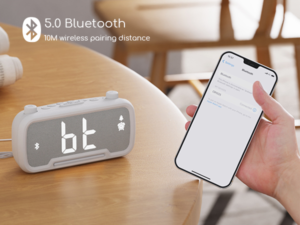 Bluetooth 5.0 alarm clock with digital display, showing 10M wireless pairing distance. Smartphone nearby demonstrating connectivity.