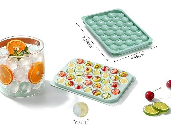 An ice tray sits on the table, next to a small bucket filled with ice and oranges.