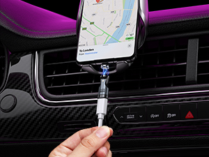 Car vent mount phone holder being inserted into dashboard air vent, with phone attachment visible.