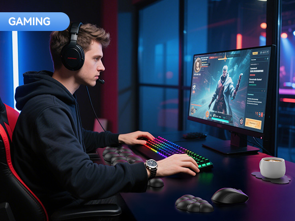 Gaming setup with RGB keyboard, large monitor displaying game interface, headphones, and gamer seated in chair. Colorful ambient lighting in background.