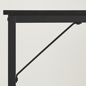 Close-up of a black metal folding shelf bracket attached to a wall, supporting a tabletop. The bracket has a simple, angular design.