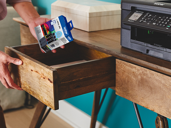 Person picking up LC401 ink cartridges from desk drawer