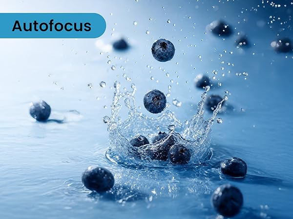 Text reads 'Autofocus'. Blueberries splashing into water against blue background, dynamic movement captured in splash sequence.