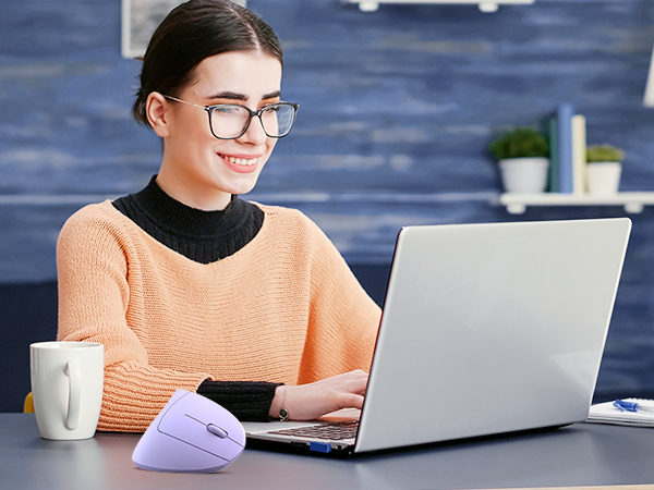 a woman sitting at a desk using a laptop