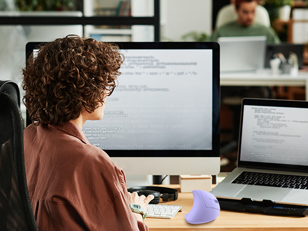 a woman sitting at a desk with a computer and a computer.