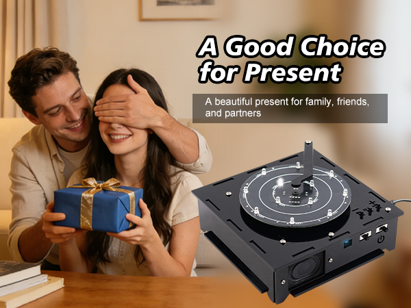 Text reads 'A Good Choice for Present', 'A beautiful present for family, friends and partners'. Male and female holding blue box gift with black electronic device, product display on polished surface.